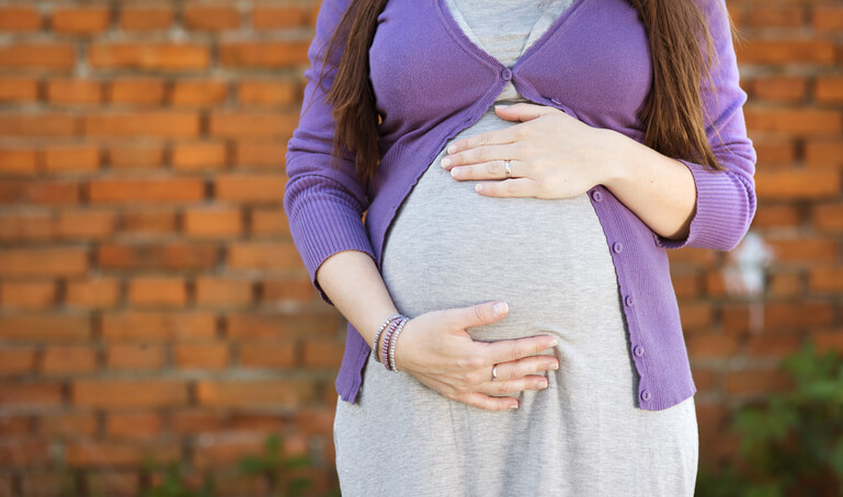pregnant woman holding her stomach